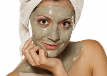 Mulher aplicando a máscara caseira e natural de argila, pepino e iogurte para tratar a pele oleosa