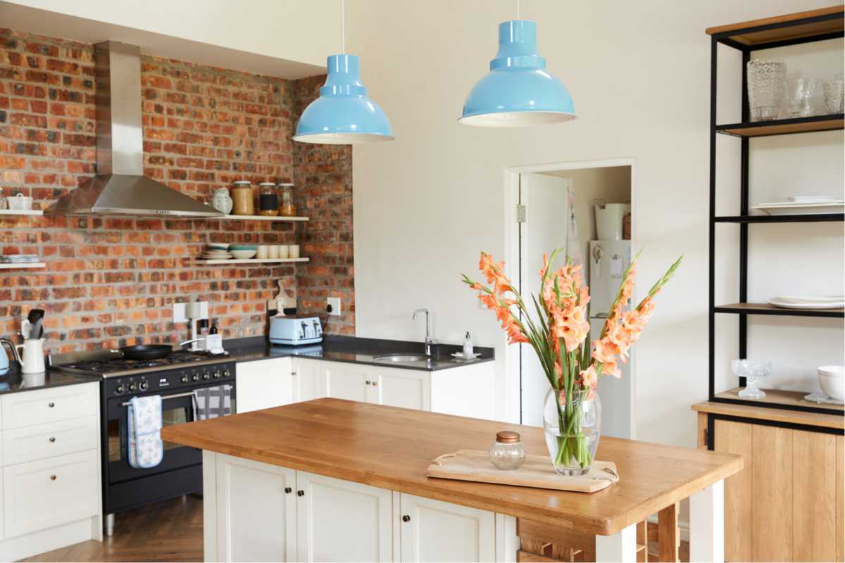 Cozinha com detalhes em madeira e luminárias azuis